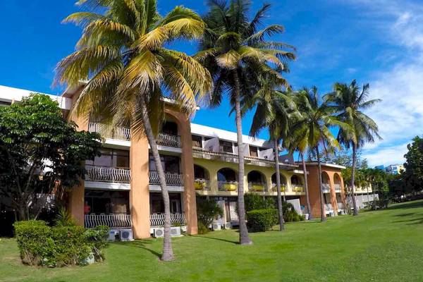 Vorderansicht des Roc Barlovento Hotels mit mehreren Etagen und Palmen davor