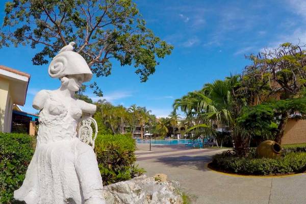 Weiße Statue eines sitzenden Mädchens im Garten des Roc Barlovento Hotels.