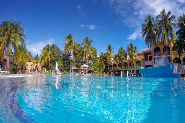 Außenpool des Roc Barlovento Hotels, umgeben von Palmen und Gebäuden.