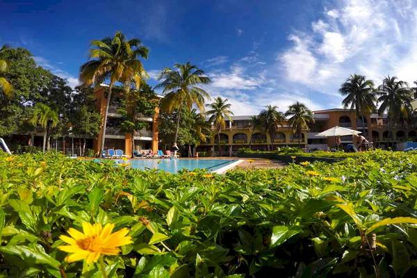 Außenpool des Roc Barlovento Hotels umgeben von Pflanzen und Palmen.