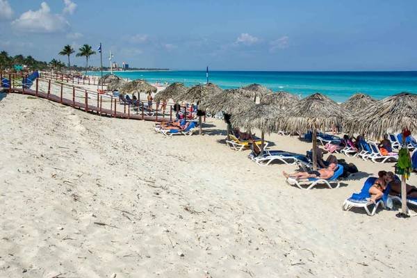 Strandszene mit vielen Liegestühlen, Sonnenschirmen und Gästen am Roc Barlovento Hotel.