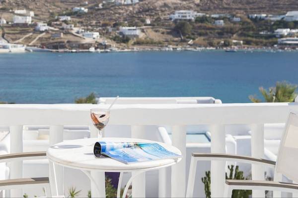 Balkon des Kivotos Mykonos mit Blick auf das Meer und weiße Gebäude im Hintergrund.
