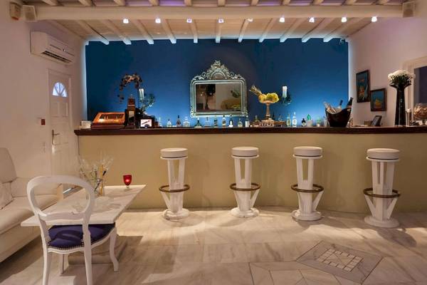 Barbereich im Kivotos Mykonos Hotel mit blauen Wänden und weißen Barhockern.