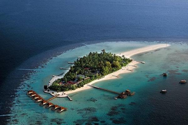 Luftaufnahme des Nakai Maayafushi Resorts auf einer Insel mit weißen Stränden, grüner Vegetation und Wasservillen.
