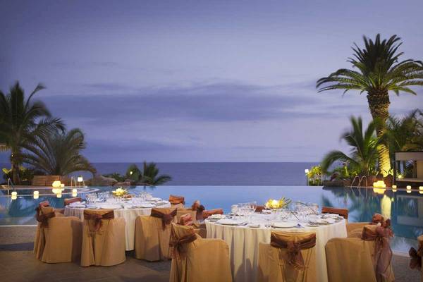 Dinnertische am Pool des Roca Nivaria Gran Hotels bei Nacht mit Blick auf den Ozean.