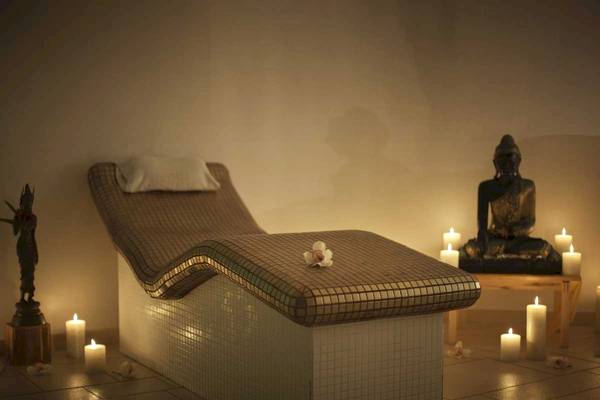 Spa-Lounge im Roca Nivaria Gran Hotel mit Liege, Kerzen und Buddha-Statue.
