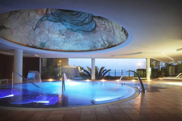 Ein Rundpool im Roca Nivaria Gran Hotel mit blauem Wasser und beleuchteter Decke.