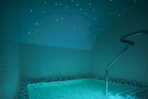 Ein kleines Schwimmbad im Roca Nivaria Gran Hotel, das bei Nacht mit blauer Beleuchtung und Sternenhimmel dekoriert ist.