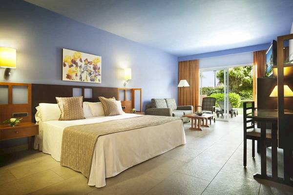 Schlafzimmer im Roca Nivaria Gran Hotel mit Doppelbett, Sofa, Tisch und Fernseher.