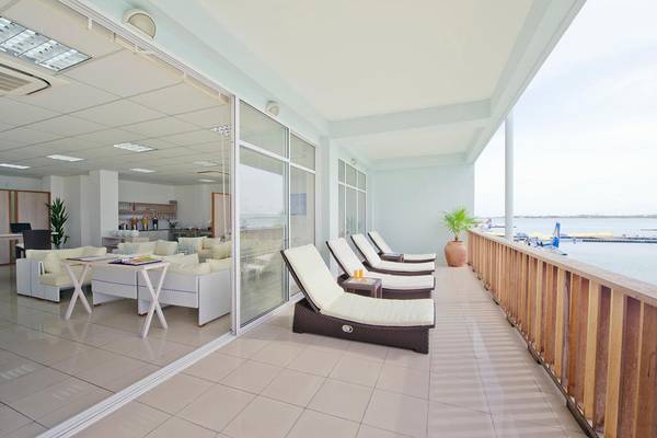Blick auf den Balkon des Kuramathi Maldives Hotels mit Lounge-Sesseln und Meersicht.