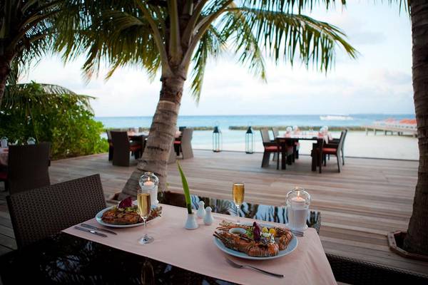 Restauranttisch am Strand des Kuramathi Maldives mit Blick auf das Meer
