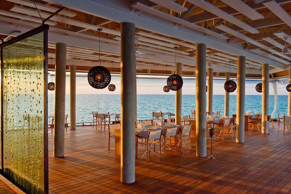 Restaurantterrasse im Kuramathi Maldives Hotel mit Blick auf das Meer.