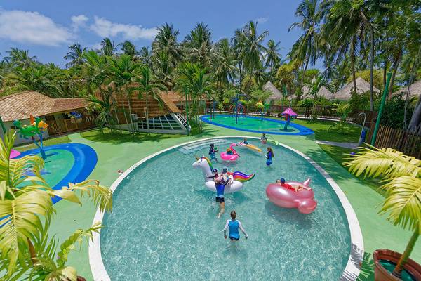 Kuramathi Maldives Außenbereich des Freizeitparks mit Pools, Spielgeräten und Kindern.
