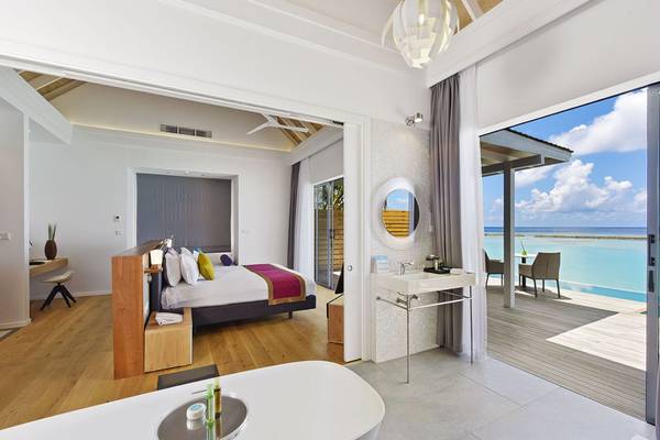Innenansicht einer Suite im Kuramathi Maldives Hotel mit Blick auf das Meer.