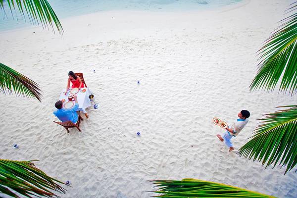 Paar genießt ein Essen auf dem weißen Sandstrand im Hotel Kuramathi Maldives.