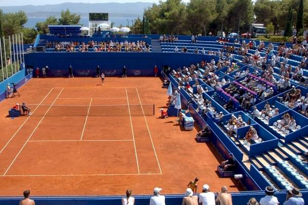 Tennisspiel im BlueSun Hotel Borak mit vollen Zuschauerrängen und Spielern auf dem Platz.