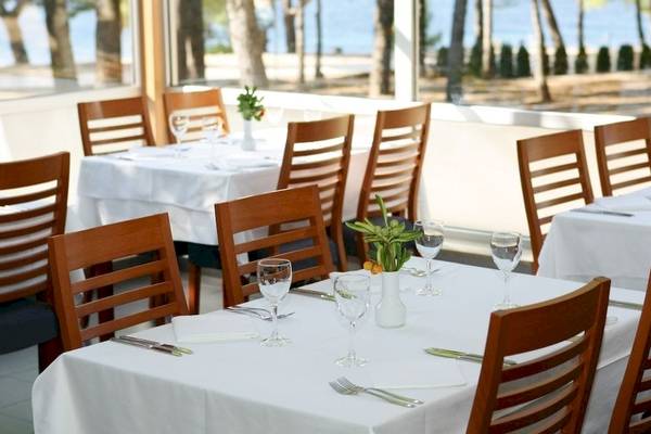 Innenansicht des Restaurants im BlueSun Hotel Borak mit Tisch und Stühlen, Blick auf das Meer.