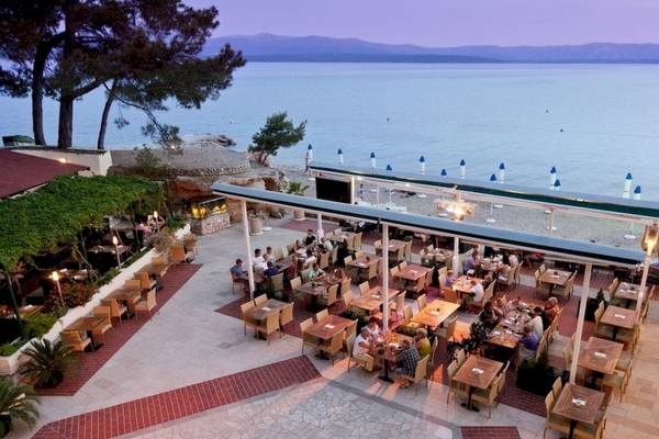 Außenterrasse des BlueSun Hotel Borak mit Blick auf den Strand und das Meer.