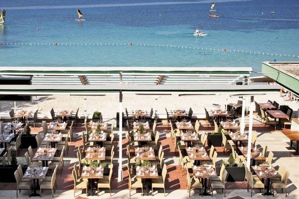 Außenterrasse des BlueSun Hotel Borak mit Blick auf das Meer und Segelboote.