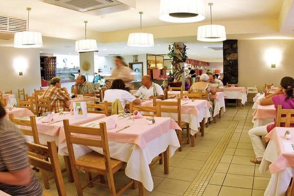 Mehrere Gäste sitzen in einem gepflegten Restaurant des Aparthotel Costa Mar.