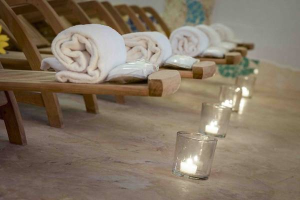 Reihe von Lounge-Stühlen mit Handtüchern und brennenden Kerzen im Grand Hotel Poltu Quatu.