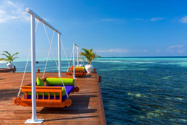 Schaukeln auf der Terrasse des Sun Siyam Olhuveli Hotels mit Blick auf das Meer.
