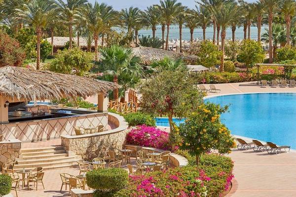 Poolbereich des Jaz Mirabel Beach Resorts mit Palmen und Sonnenliegen