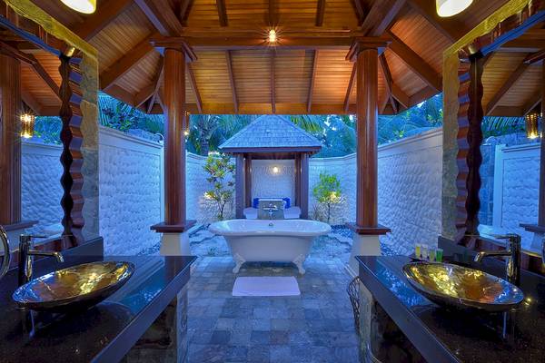 Ein Badezimmer mit freistehender Badewanne und zwei Waschbecken im Freien, Sun Siyam Olhuveli.