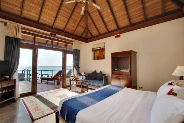 Ein Schlafzimmer im Sun Siyam Olhuveli Hotel mit Blick auf das Meer.