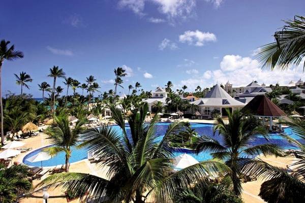 Poolbereich des Bahia Principe Luxury Esmeralda Hotels mit Palmen und Sonnenliegen.