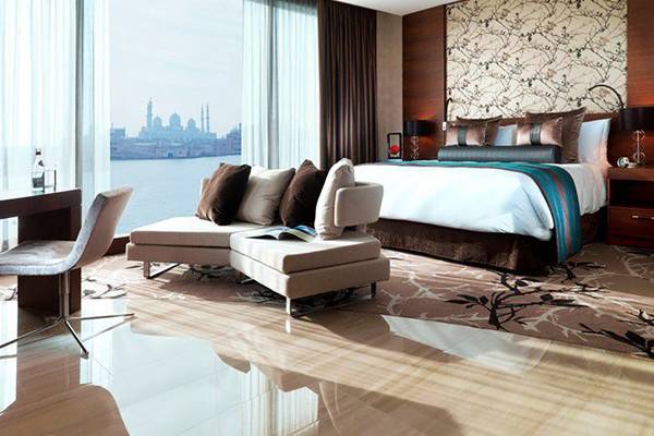 Suite-Zimmer im Fairmont Bab Al Bahr mit Blick auf die Stadt und Wasser.