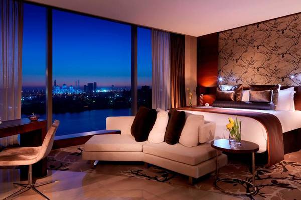 Hotelzimmer im Fairmont Bab Al Bahr mit Blick auf die Stadt und den Fluss bei Nacht.