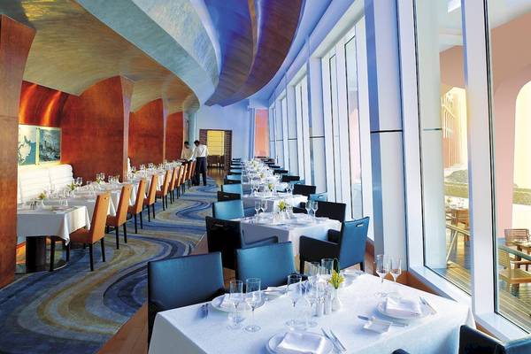 Restaurant im Shangri-La Al Husn Resort & Spa mit gedeckten Tischen und Blick auf die Außenterrasse.
