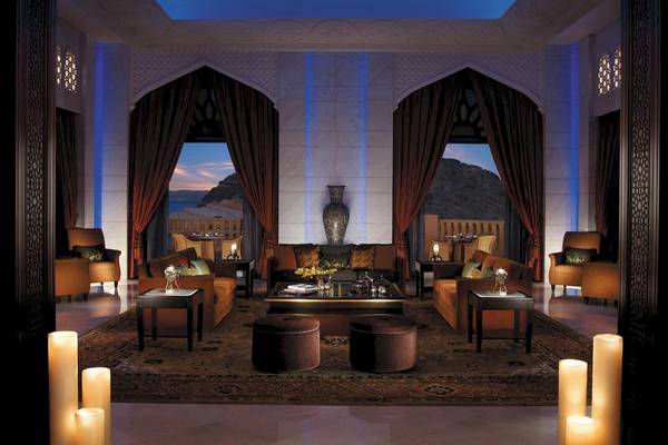 Hotelloungebereich mit Sofas, Tischen und einem großen Vase auf dem Tisch.