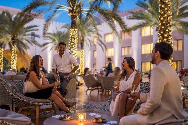 Gruppe von Menschen, die im Shangri-La Al Husn Resort & Spa Spaß haben, darunter zwei Frauen und zwei Männer, die Wein trinken.