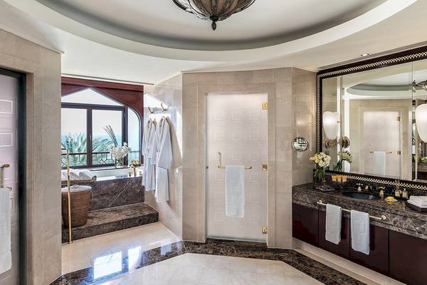 Luxuriöses Badezimmer im Shangri-La Al Husn Resort & Spa mit Badewanne, Waschbecken und Spiegel.