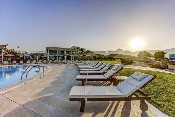 Poolbereich des Candia Maris Resort & Spa mit Liegestühlen und Sonnenschirmen.