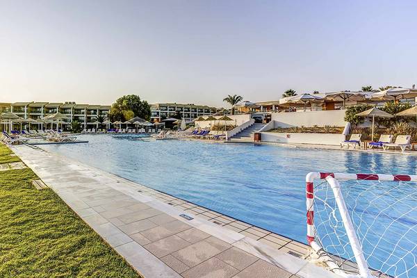 Außenpool des Candia Maris Resort & Spa mit Sonnenliegen und Sonnenschirmen.