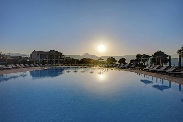 Candia Maris Resort & Spa Pool am Abend mit Sonnenuntergang im Hintergrund.