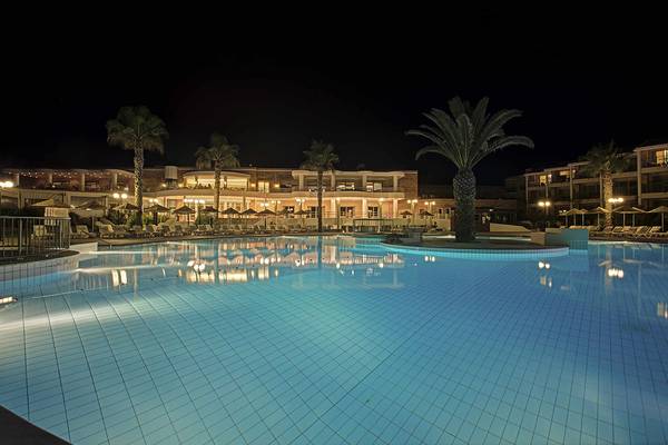 Nachtansicht des Swimmingpools und der Loungeliegen des Candia Maris Resort & Spa