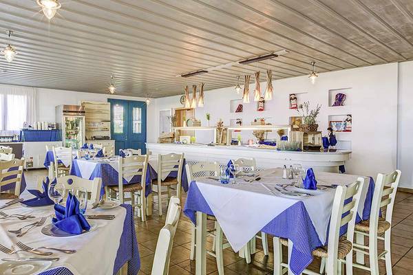 Innenbereich des Restaurants im Candia Maris Resort & Spa mit gedeckten Tischen und Stühlen.