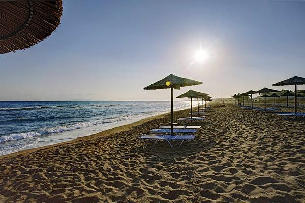 Strand des Candia Maris Resort & Spa mit Sonnenschirmen und Liegen