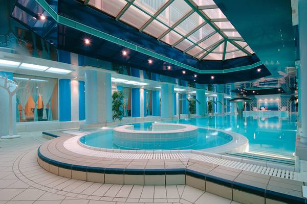 Innenpoolbereich des Candia Maris Resort & Spa mit blauen Säulen und Glasdach
