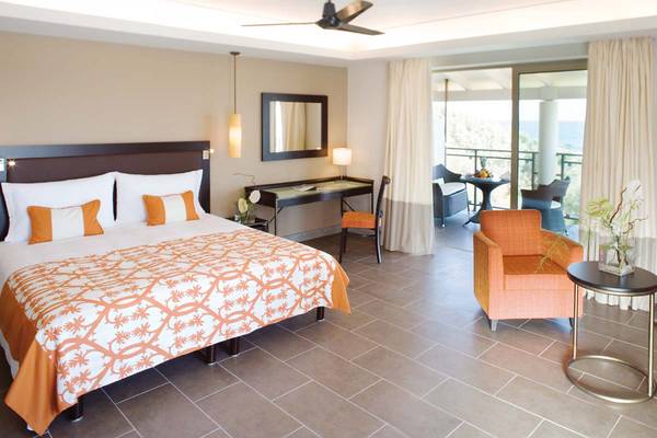 Hotelzimmer im Candia Maris Resort & Spa mit Bett, Schreibtisch und Balkon.