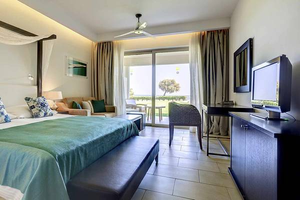 Hotelzimmer im Candia Maris Resort & Spa mit Bett, Fernseher und Balkon.