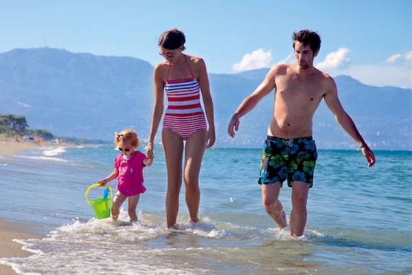 Familie am Strand von Belambra Clubs Pineto, ein Erwachsener und ein Kind gehen ins Wasser.