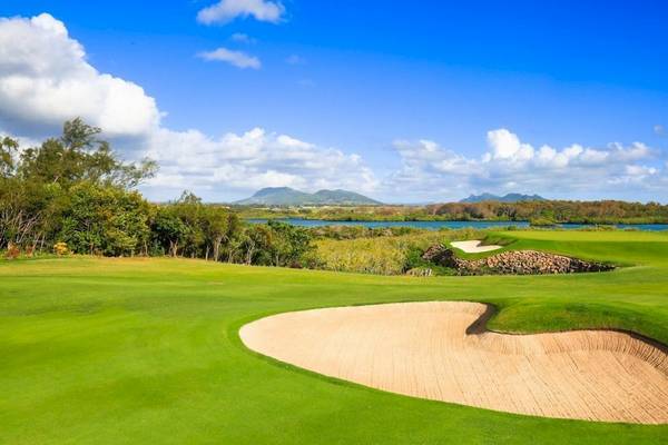 Golfplatz bei La Pirogue Mauritius mit Wasserhindernis und blauem Himmel