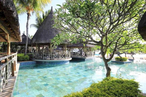 Außenbereich des La Pirogue Mauritius Resorts mit Swimmingpool und Pavillons.
