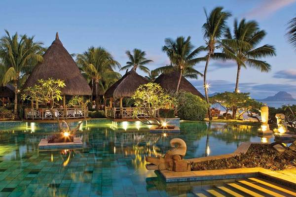 Nachtaufnahme des Pools im La Pirogue Mauritius Hotel mit illuminierten Gebäuden und Wasserbeleuchtung