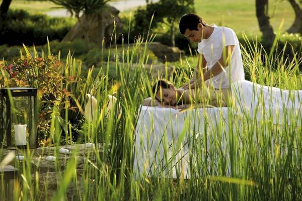 Eine Frau erhält eine Massage im Garten des Sani Clubs.